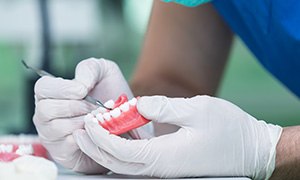 A dental technician working on a denture