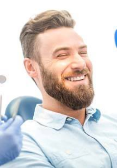 Man with beard smiling in dental chair