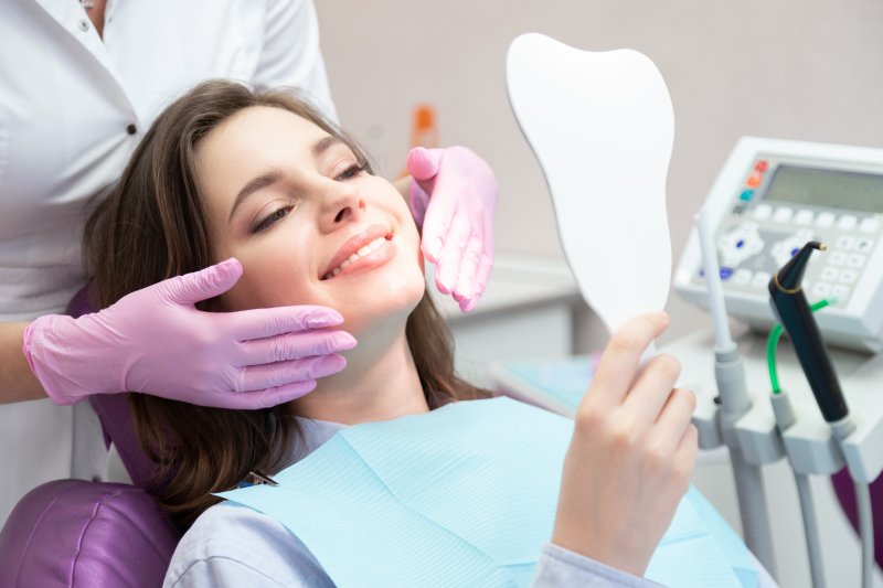 a woman smiling in the dentist’s treatment chair