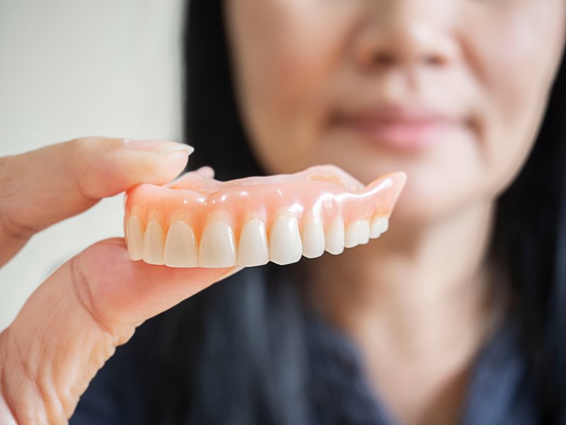 Woman holding a denture